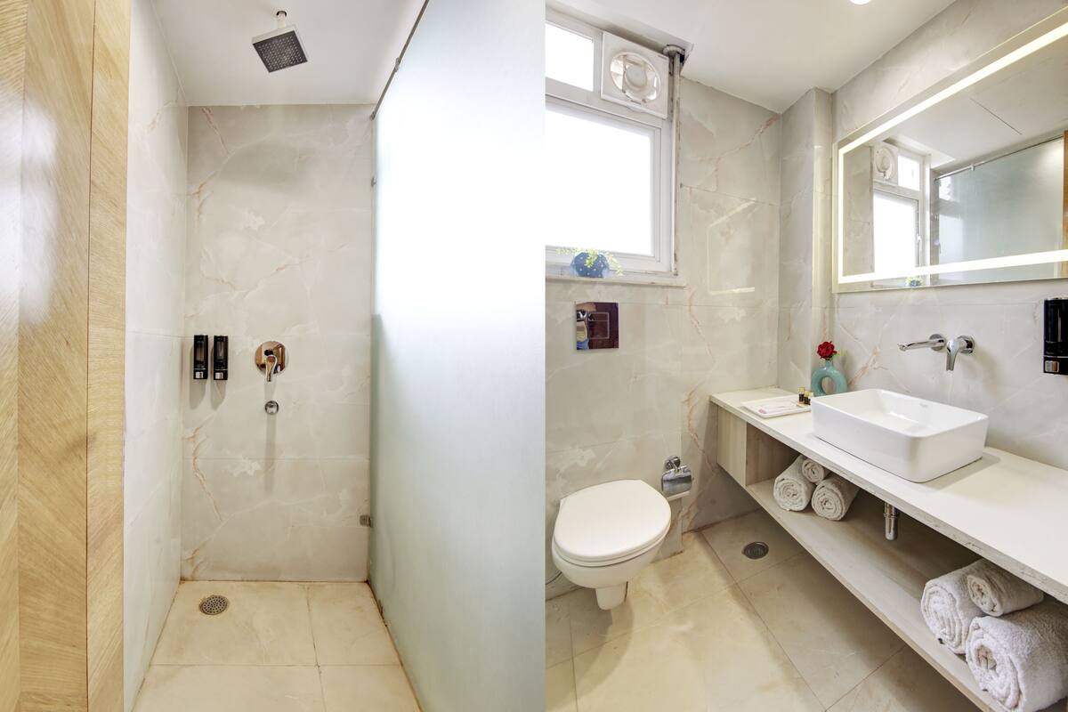 Une salle de bain avec douche, toilettes et lavabo.