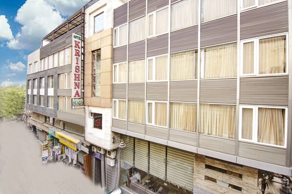 Un immeuble à plusieurs étages sur lequel on peut lire l’inscription « Krishna Plaza ».