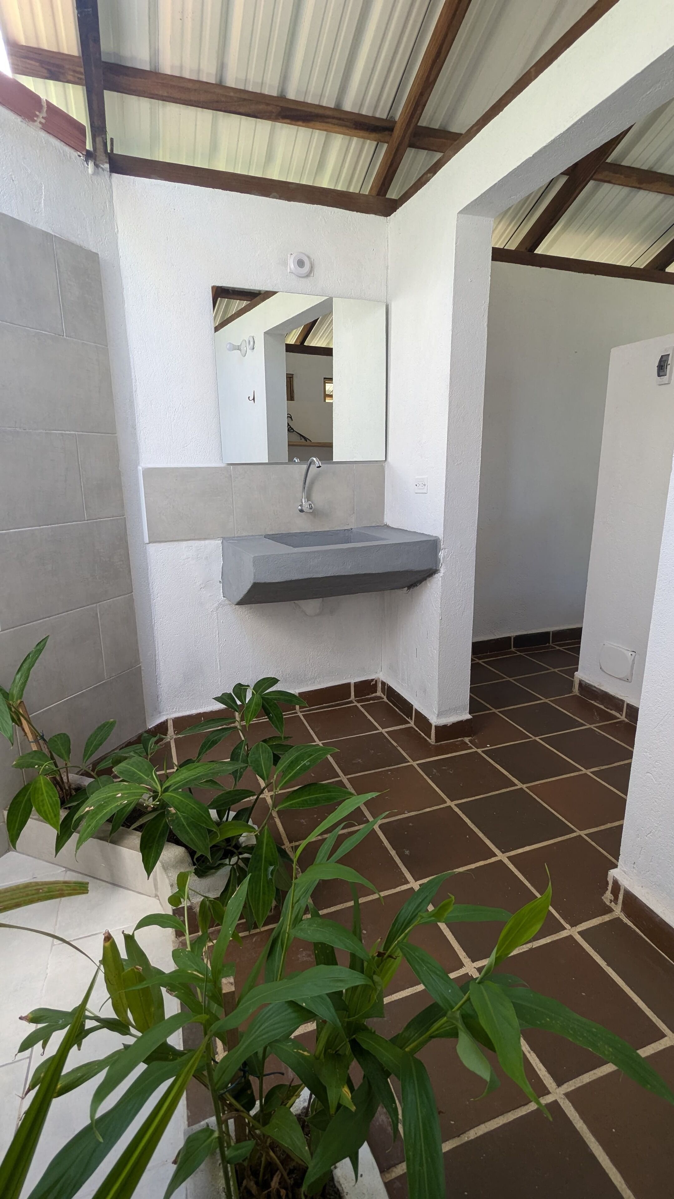 A bathroom with a sink, mirror, and tiled floor.