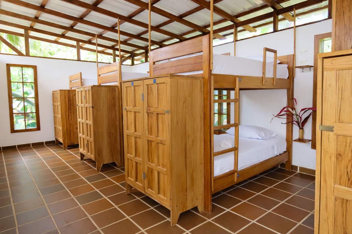Ein Zimmer mit Etagenbetten, Holzschränken und Fliesenboden.