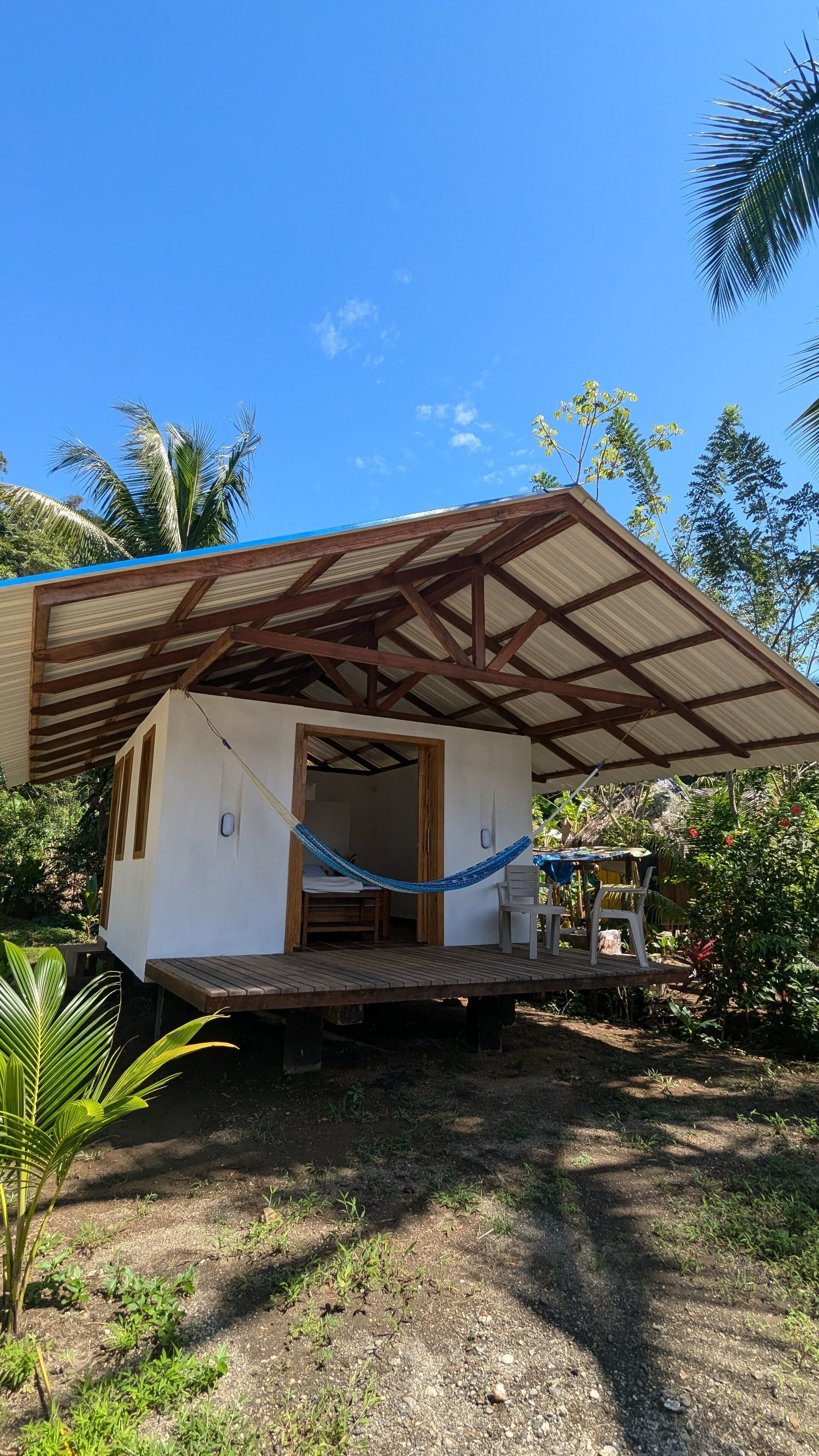 A small, single-story structure with a corrugated metal roof and a wooden deck.
