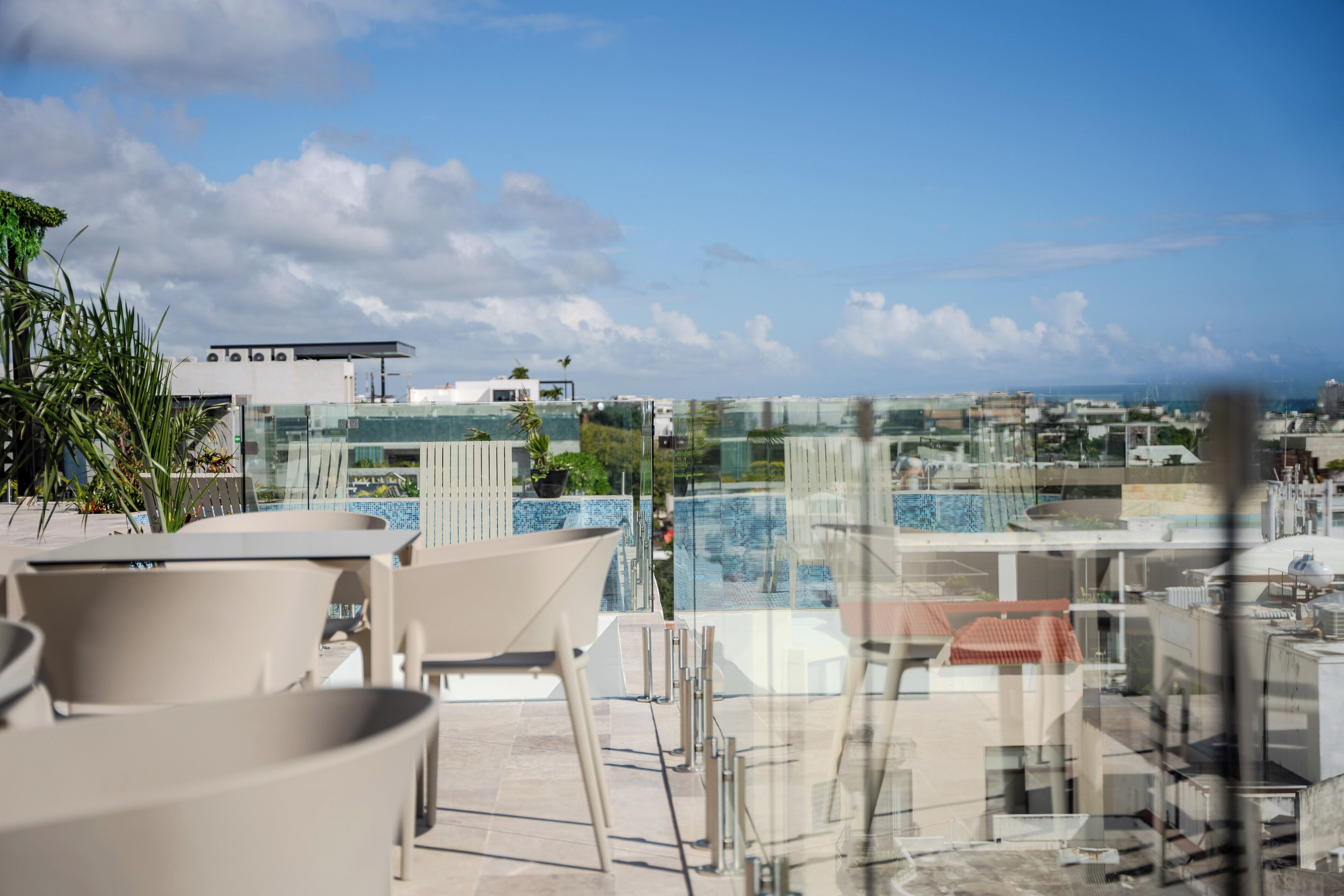 A rooftop terrace with outdoor seating, a pool, and a view of the cityscape.