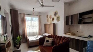 Een moderne woonkamer met een bank, een bijzettafeltje en een plafondventilator.