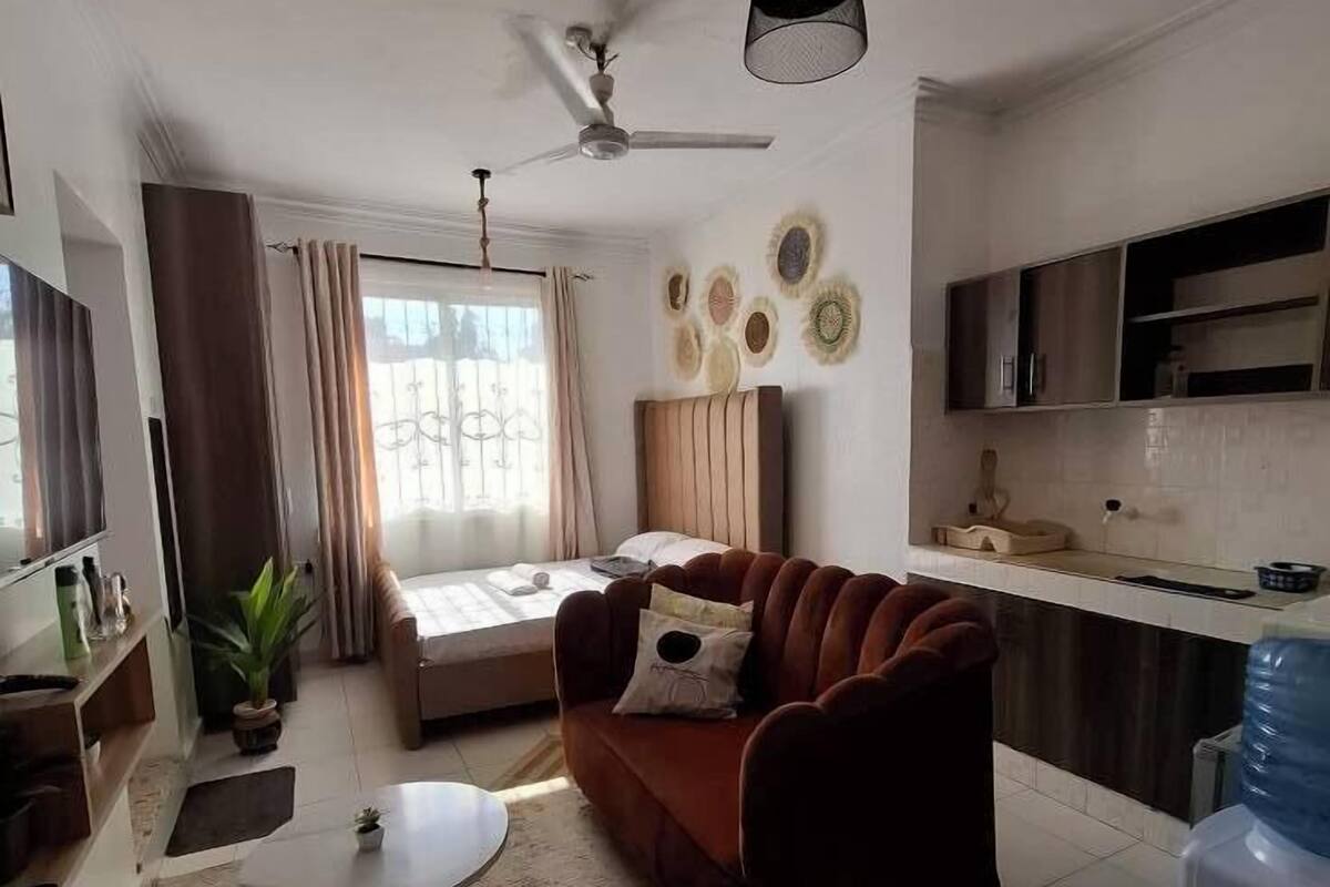 Uma sala de estar moderna com um sofá, uma mesa de centro e um ventilador de teto.