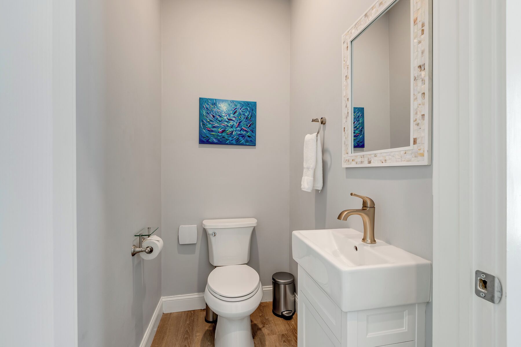 A small bathroom with a toilet, sink, and a mirror.