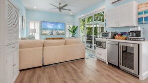 A modern kitchen with built-in appliances, a dining area with a view, and a cozy living space with a sofa and a TV.