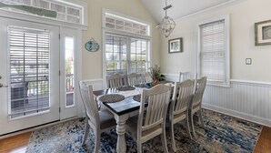 A dining area with a wooden table, white chairs, and a blue patterned rug. - 3-bedroom condo in delightful Ocean City with WiFi, AC (Ocean City)