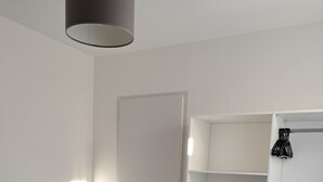 A bedroom with a bed, a wardrobe, and a door.