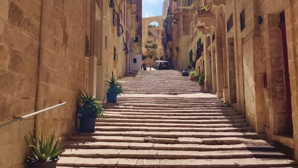 Eine schmale Steintreppe führt zu einem Hauseingang in einer historischen Stadt.