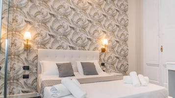 A hotel room with a bed, two wall-mounted lamps, a large mirror, and a wardrobe.