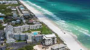 An aerial view of a coastal hotel with multiple buildings, a beach, and a swimming pool. - Sand Cliffs 108: Steps to beach & pool access + Free Attraction Tickets! (Seacrest Beach)