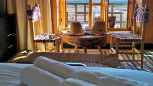 A hotel room with a bed, a window with curtains, a table with a hat, and a chair. - Villa Calm, Panoramic View of the Lake and Mountains, Ouarzazate Center (Ouarzazate)