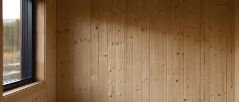 A room with wooden panel walls, a window, and a built-in bench.