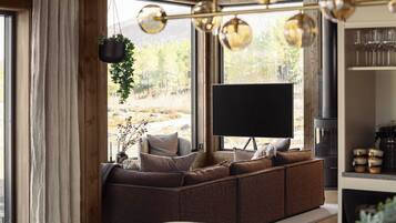 A cozy living room with a large sectional sofa, a flat-screen TV, and a dining area with a wooden table and chairs.