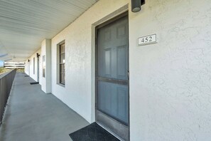 A corridor with a door marked 452, a metal handrail, and a concrete floor. - I-452 - Remodeled, Luxury Condo with Lake Views (Naples)
