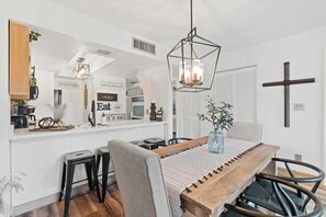 A modern kitchen with white cabinetry, a wooden island, and a hanging light fixture. - G-243 - Spend Your Vacation in Luxury with Pool (Naples)