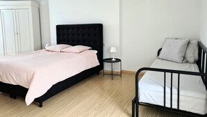 A bedroom with a large bed, a smaller bed, a wardrobe, and a bedside table with a lamp. - La Belle de Jard - 8 people (Jard-sur-Mer)