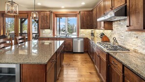 A spacious kitchen with wooden cabinets, a granite countertop, and a stainless steel dishwasher. - Walk to the Winery & Chip onto the Par 3 Course! (Cle Elum)