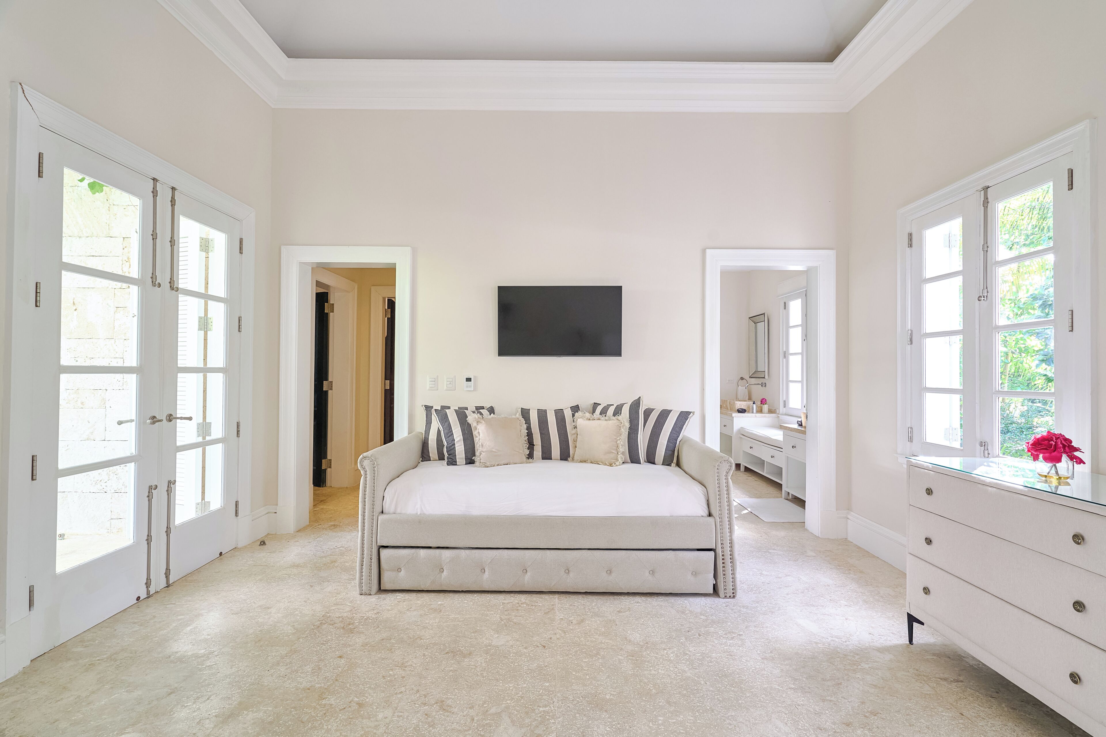 A bedroom with a bed, a television, and a dresser.