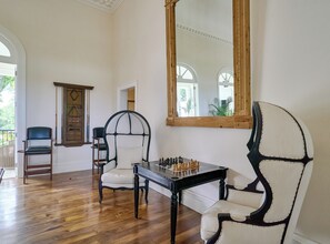 A room with a chessboard, a mirror, and two chairs. - Luxurious Ocean and Golf View Villa staffed with Private Chef, Butler and Maid! (Punta Cana)