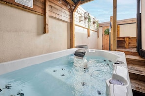 Un jacuzzi con terraza de madera y una pérgola.
