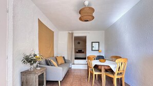 A dining area with a wooden table, chairs, and a grey sofa. - Domaine de La Blache - The Vault (Saint-Jurs)