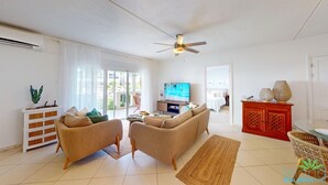 A spacious living room with two sofas, a television, a ceiling fan, and a red cabinet. - ☀️⛱️Beachside by IRE Vacations - 3 bedroom Condo on Simpson Bay Beach 🌴 (Simpson Bay)