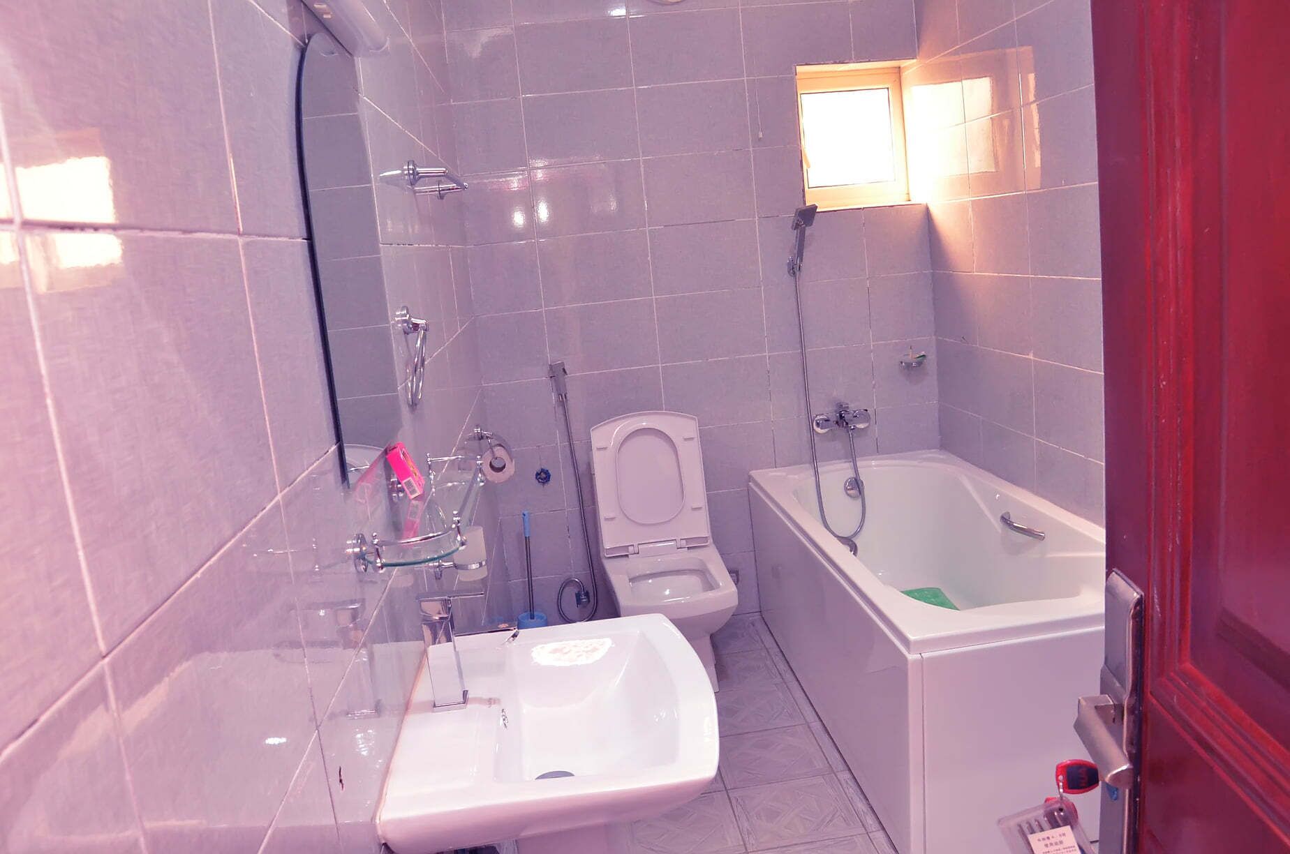 A bathroom with a bathtub, a toilet, and a sink.