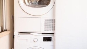 A stacked washer and dryer unit in a laundry room. - RoomApartment Rome: 1 Bedroom Apartment with Balcony  (Roma)