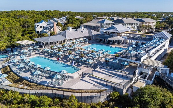 A resort with multiple swimming pools, sun loungers, and umbrellas.