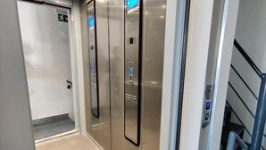Un ascensor moderno con pantallas digitales y paneles de control.