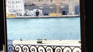Vista al agua con edificios, un muelle y una barandilla.