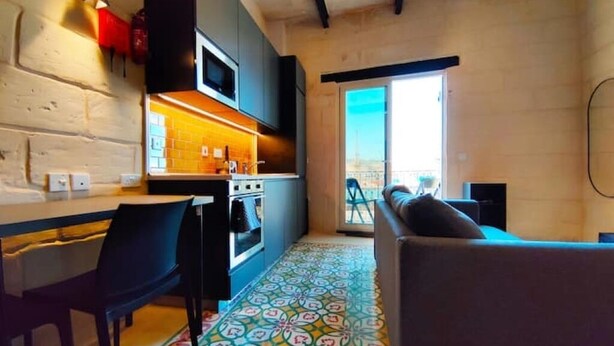Una cocina moderna con comedor, piso estampado y vistas a través de un ventanal.