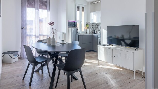 Eine moderne Küche mit Einbauofen, Mikrowelle und einem großen Flachbildfernseher.