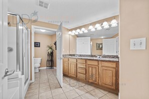 A modern kitchen with wooden cabinets, a granite countertop, and a large island. - Legacy Tower II 509 | Deluxe Unit with Stunning Coastal Views! (Gulfport)