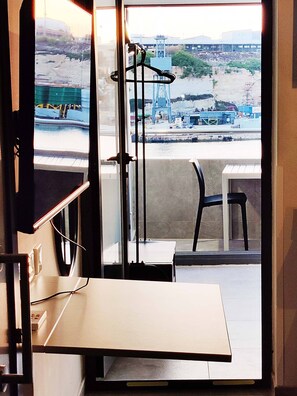 Une pièce donnant sur une zone industrielle, avec une table, une chaise et un porte-manteau.