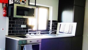 Una cocina moderna con microondas, horno y lavamanos.
