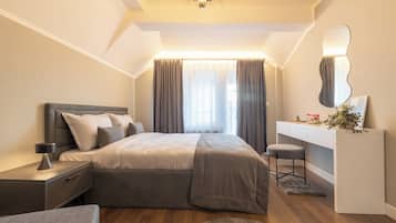 Une chambre moderne avec un lit, des tables de chevet, un bureau, un miroir et une fenêtre avec des rideaux.