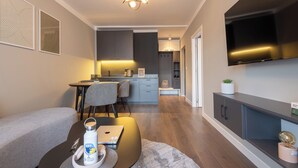 Una sala de estar moderna con un sofá, una mesa de centro y un televisor montado en la pared.