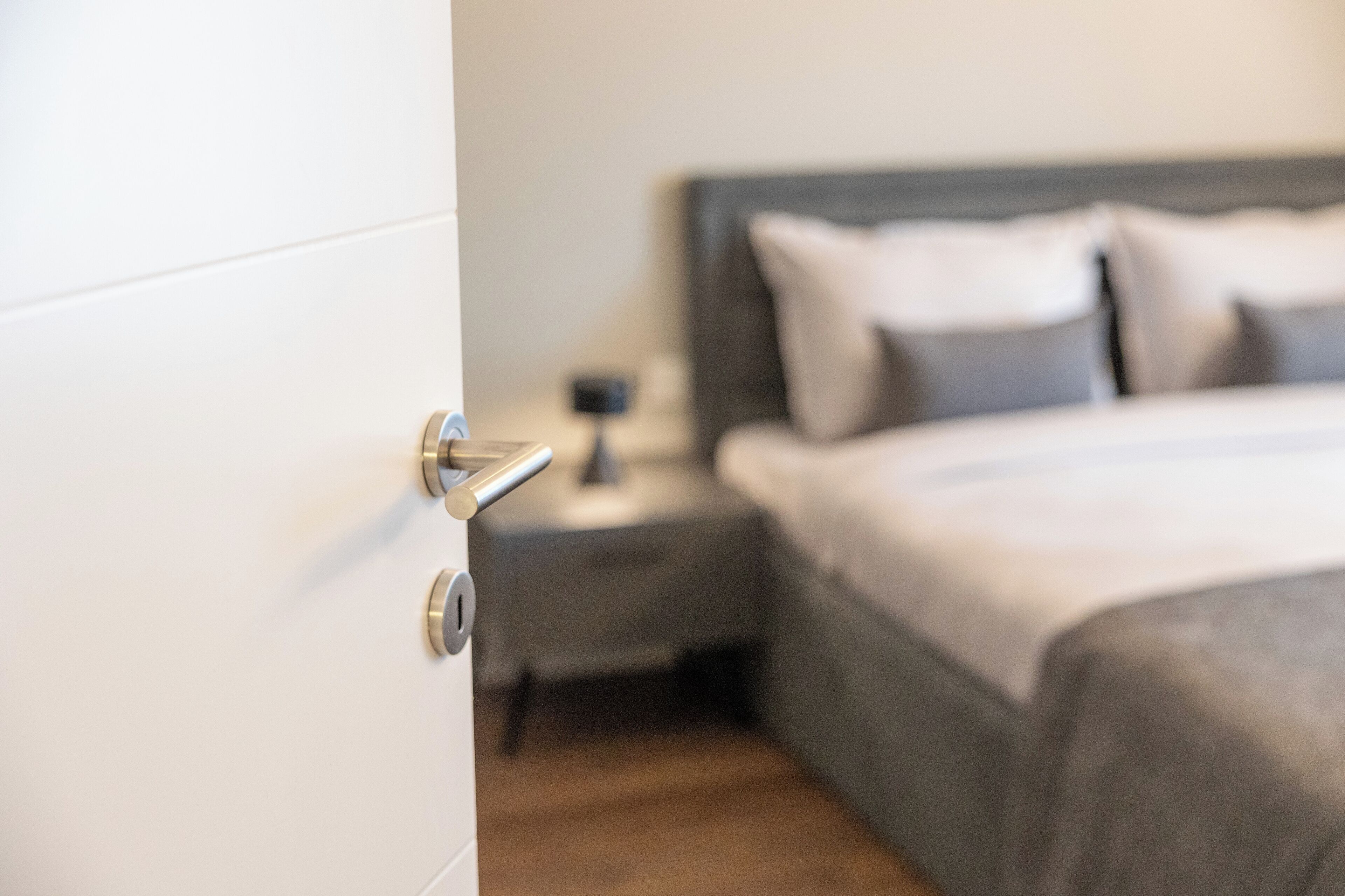 Un dormitorio con cama, mesita de noche y una puerta.