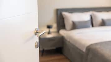 Un dormitorio con cama, mesita de noche y una puerta.