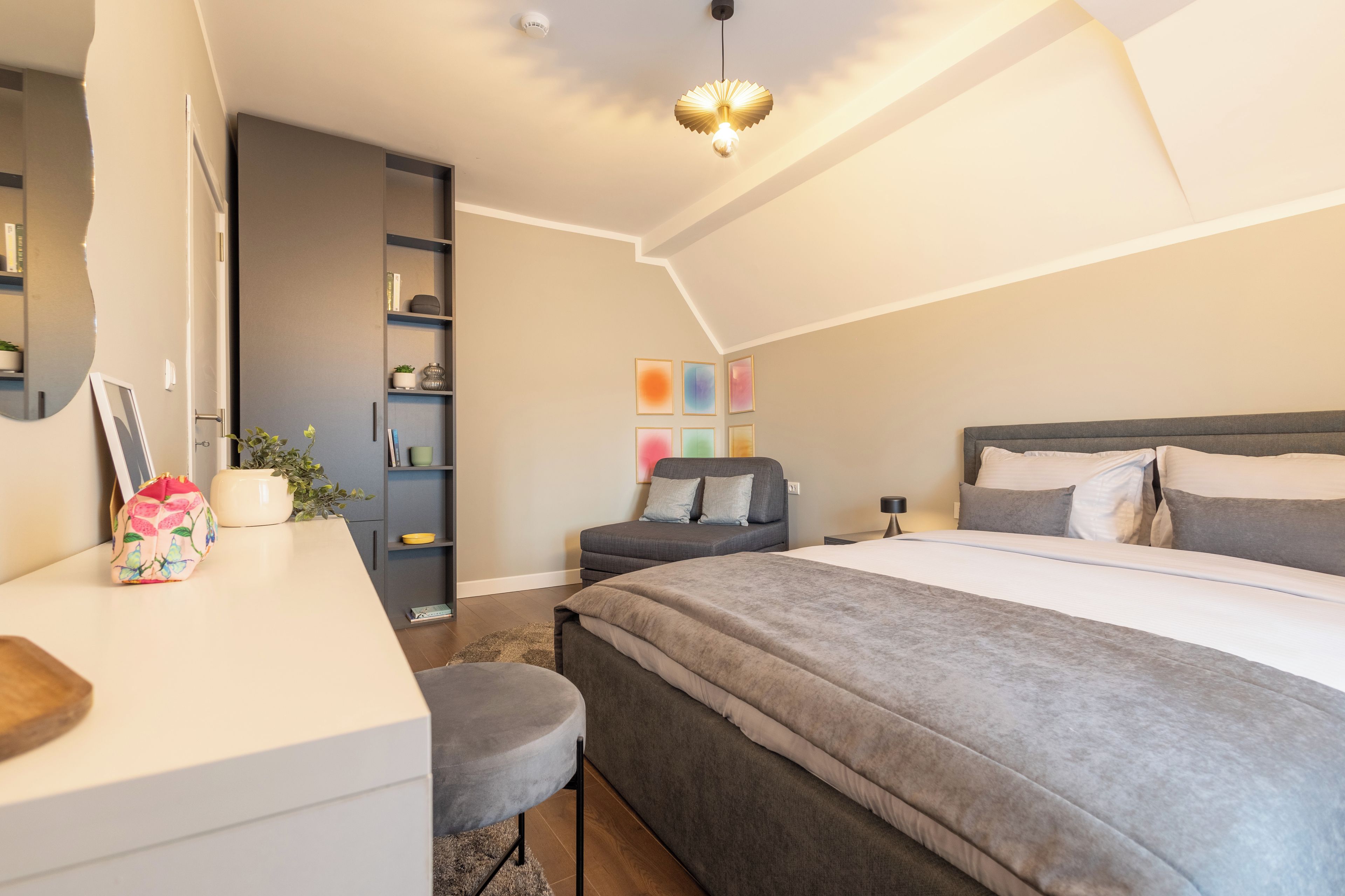 Ein modernes Schlafzimmer mit einem großen Bett, einem Schreibtisch und einem Bücherregal.