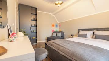 Ein modernes Schlafzimmer mit einem großen Bett, einem Schreibtisch und einem Bücherregal.