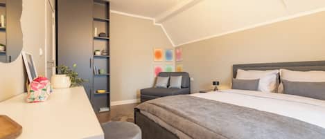Un dormitorio moderno con una cama grande, un escritorio y una estantería.