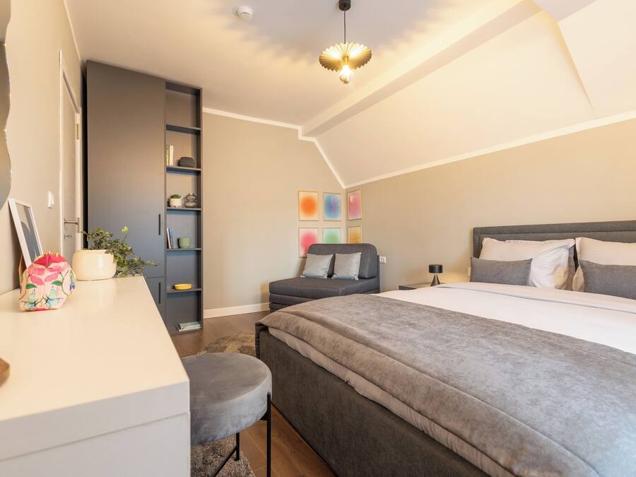 Une chambre à coucher moderne avec un grand lit, un bureau et une bibliothèque.