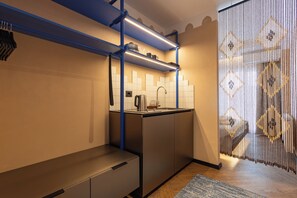 Una cocina moderna con horno empotrado, cafetera y hervidor sobre la encimera.