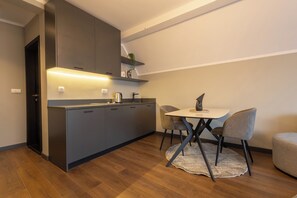 Una cocina moderna con una isla integrada, un comedor con mesa y sillas, y una pequeña zona de estar con sofá.