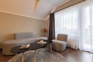 Una sala de estar moderna con un sofá, una mesita y una revista, y una silla.