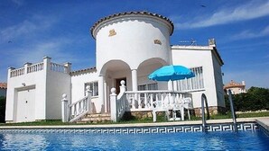 A white building with a pool, a blue umbrella, and a staircase leading to the entrance. - SAONA VILLAS (VN ELEN): villa for 6 people, private pool, wifi, air conditioning (Les Tres Cales)