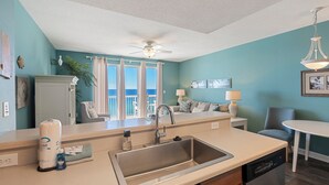 Una cocina moderna con una isla grande, lavavajillas integrado y vistas al exterior.
